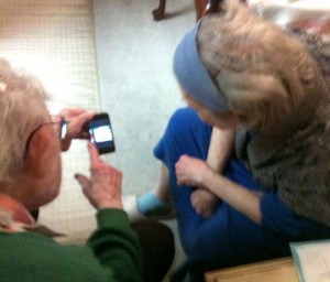 Granpa shows off ipod to Grandma. 